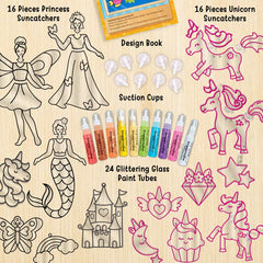 Set of princess, unicorn, and fairy suncatchers with design book, paint tubes, and suction cups on a wooden surface.