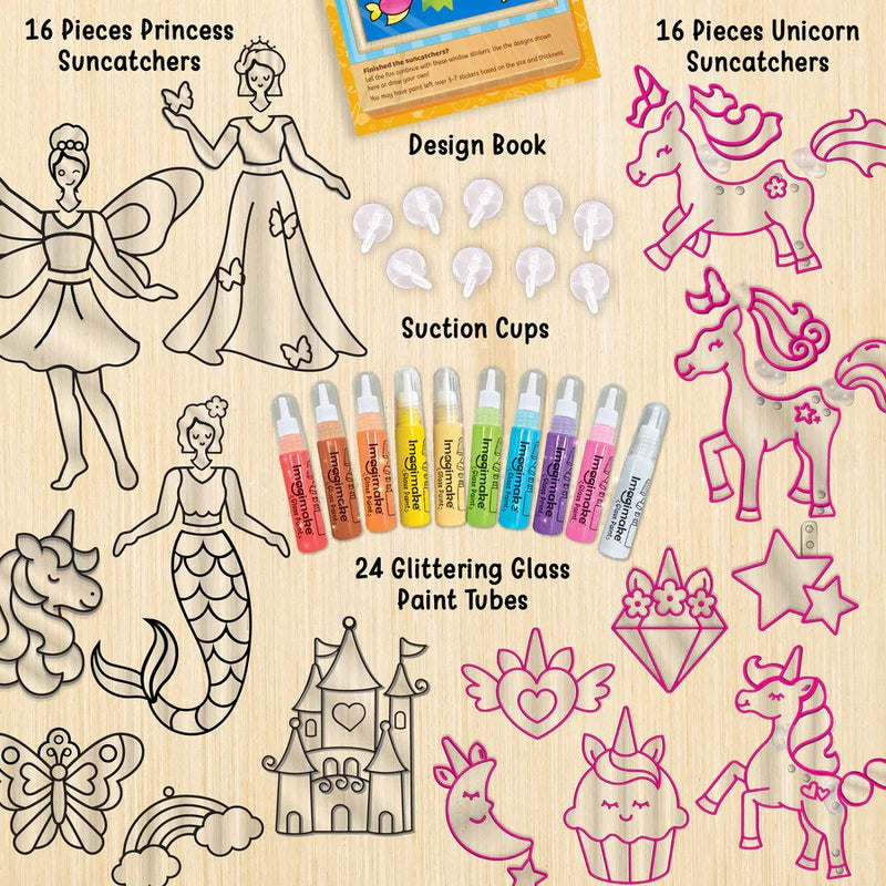 Set of princess, unicorn, and fairy suncatchers with design book, paint tubes, and suction cups on a wooden surface.