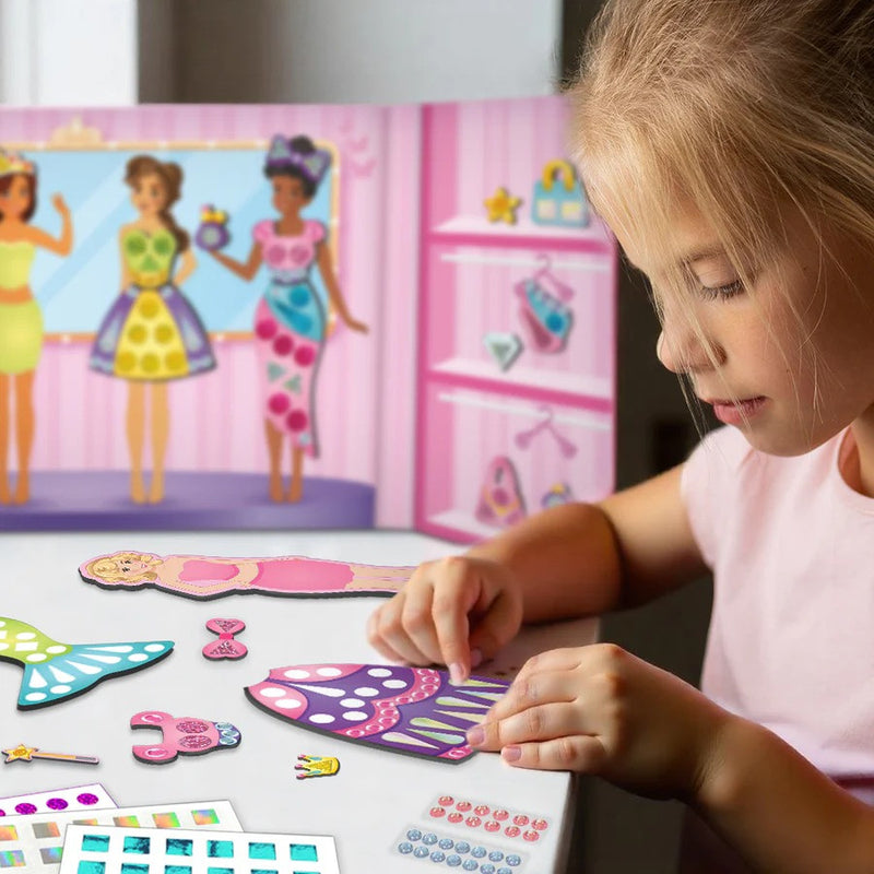 Child playing with colorful paper crafts in front of a toy box