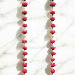 Pair of long earrings with pink beads on a white background