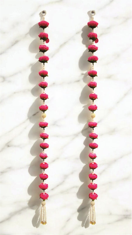 Pair of long earrings with pink beads on a white background