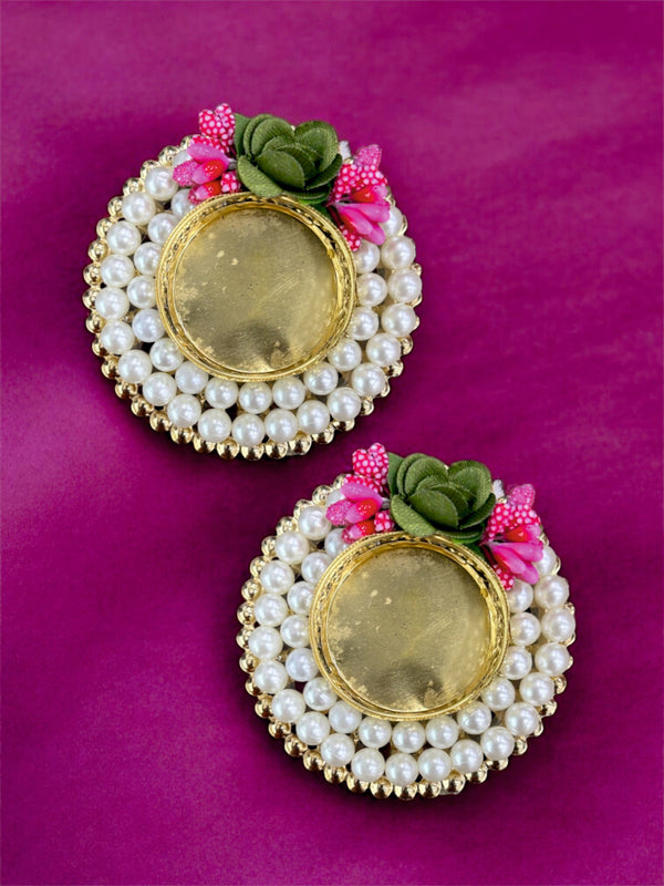Pair of earrings with pearl and gold details on a purple background