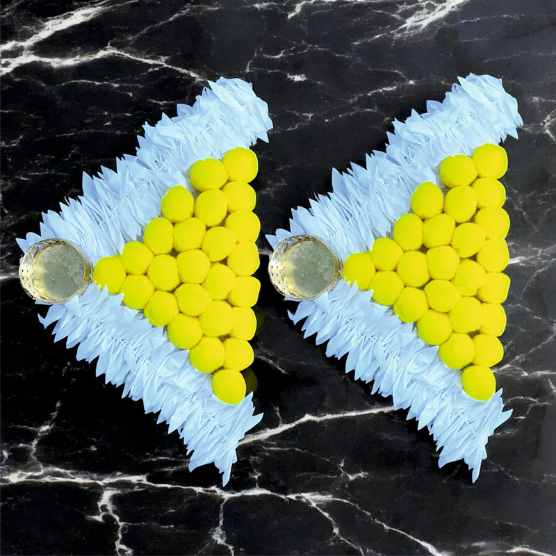 Heart-shaped earrings with yellow beads and blue 'N' shapes on a black marble background