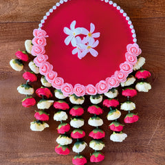 Decorative pink plate with floral designs on a wooden surface