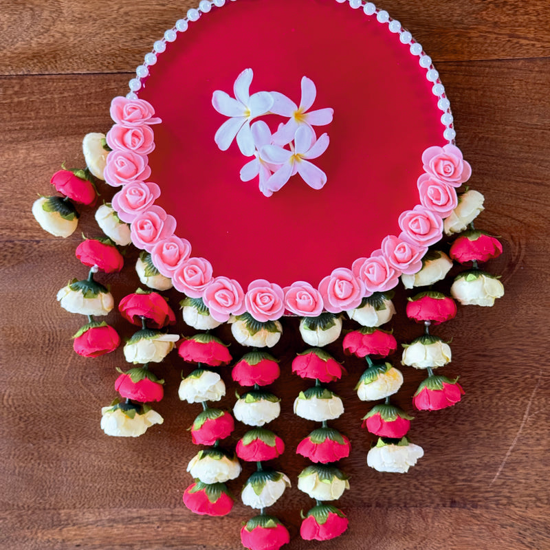 Decorative pink plate with floral designs on a wooden surface