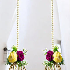 Two decorative items resembling gold birdcages with flowers on a white background