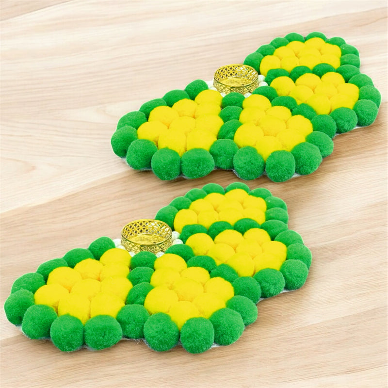 Green and yellow pom-pom sandals on a wooden surface