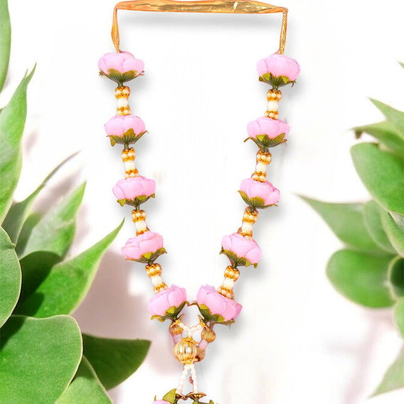 Necklace with pink floral beads and gold accents on a white background with green leaves.