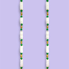 Decorative door toran with white, green, and gold beads on a purple background