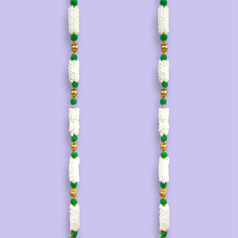 Decorative door toran with white, green, and gold beads on a purple background