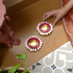 Decorative oil lamps with floral designs on a wooden surface.