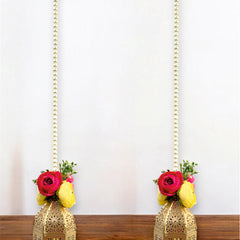 Two decorative hanging lanterns with floral arrangements on a wooden surface.