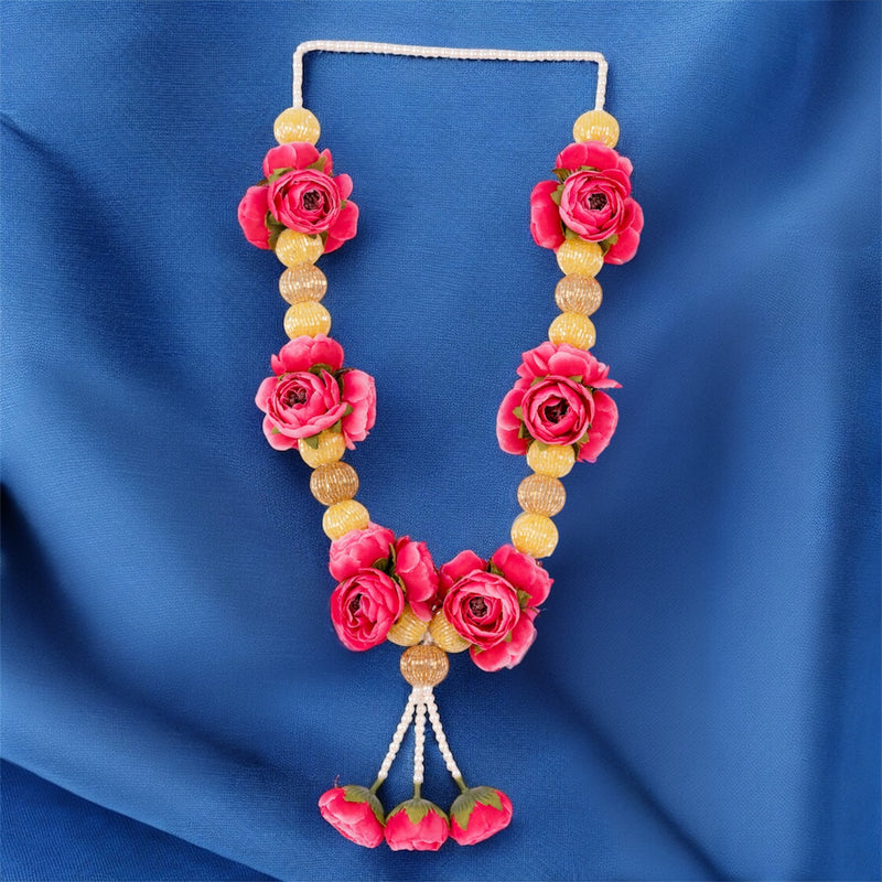 Necklace with pink floral and yellow bead design on a blue fabric background