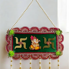 Decorative wall hanging with Swastika design and Lord Ganesha on a green background.