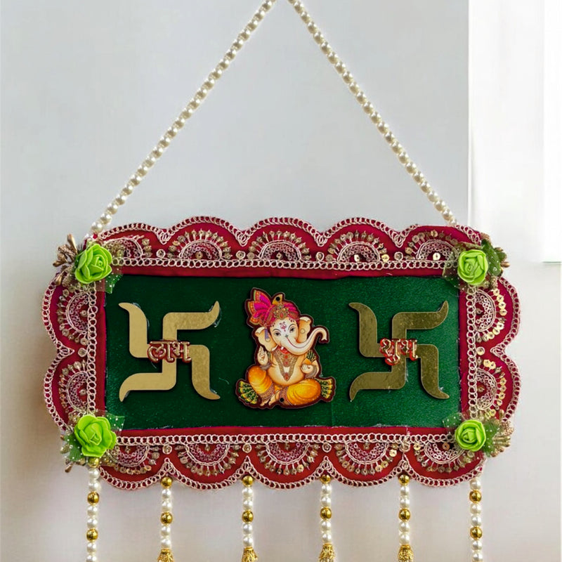 Decorative wall hanging with Swastika design and Lord Ganesha on a green background.