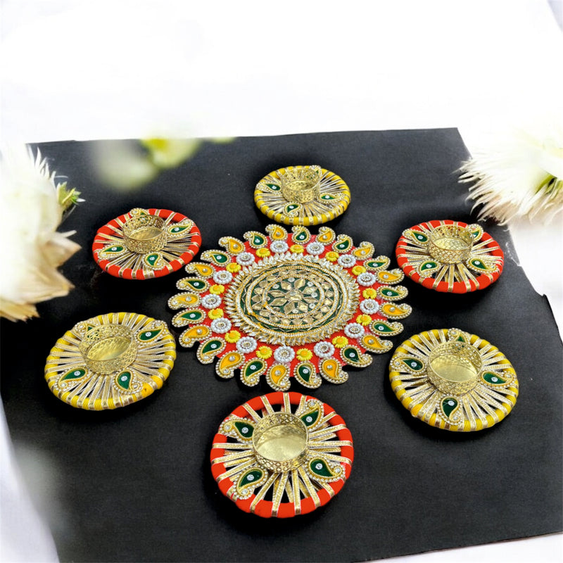 Decorative colorful pattas on a black surface with flowers in the background