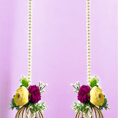 Decorative earrings with floral elements and gold cage design on a purple background