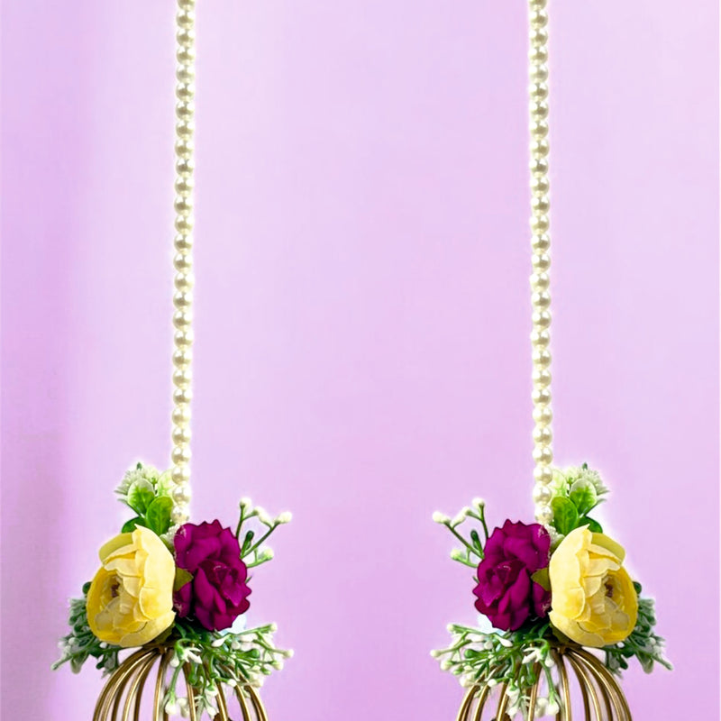 Decorative earrings with floral elements and gold cage design on a purple background