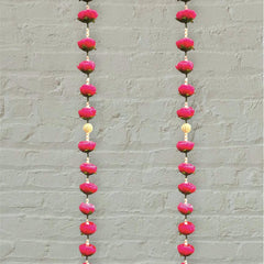 Long earrings with pink and red beads on a gray background