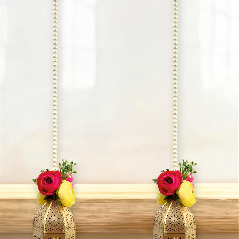 Decorative lanterns with floral elements on a wooden surface