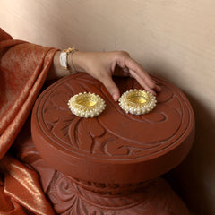 Person holding a red decorative box with gold embellishments