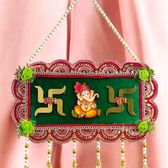 Decorative wall hanging with Swastika design and Lord Ganesha on a pink background