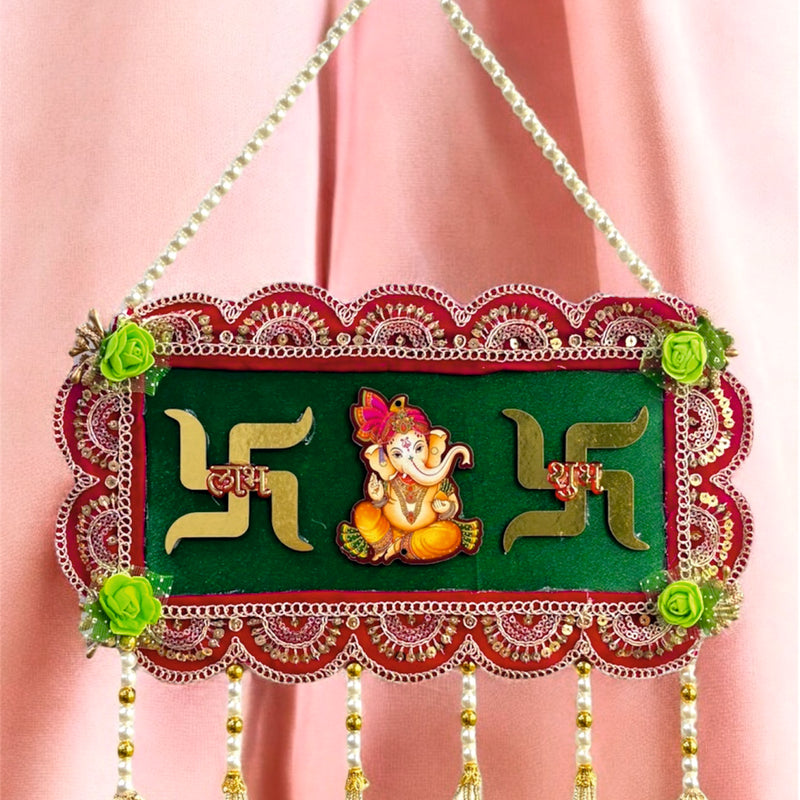Decorative wall hanging with Swastika design and Lord Ganesha on a pink background