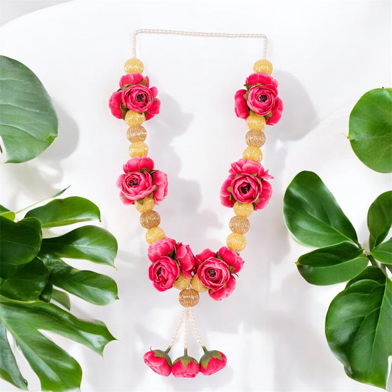 Necklace with pink flowers and gold beads on a white background with green leaves.