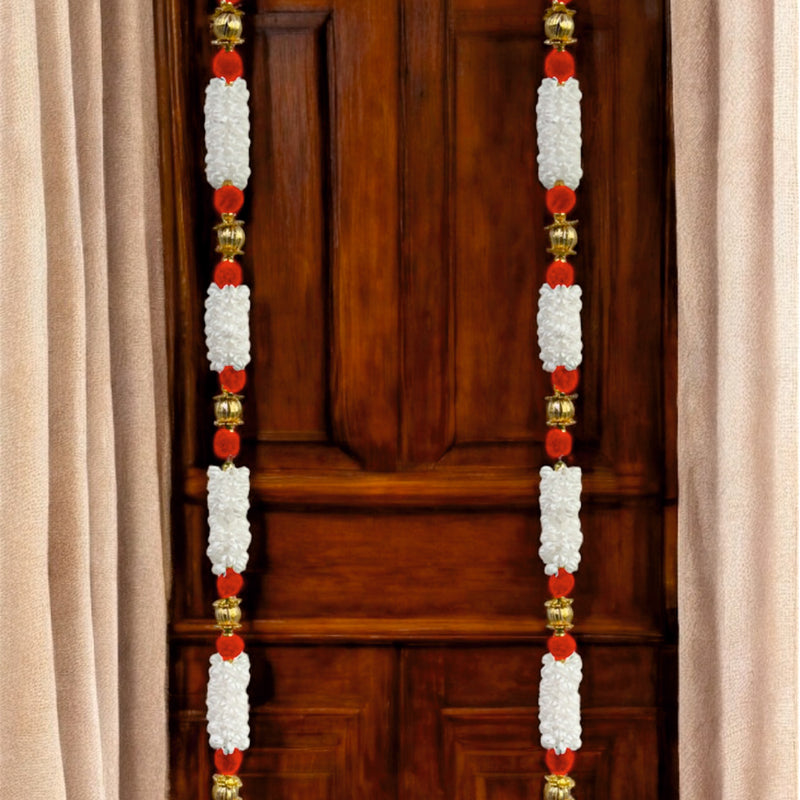 Decorative door hanging with red and white flowers on a wooden door.