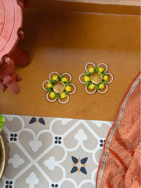 Decorative earrings on a brown surface with a patterned floor in the background