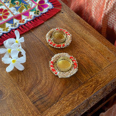 Decorative items on a wooden surface with a colorful fabric in the background