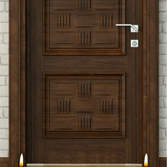 Wooden door with two lit candles on a wooden floor in front of it.