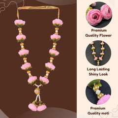 Decorative necklace with pink flowers and gold accents on a brown background