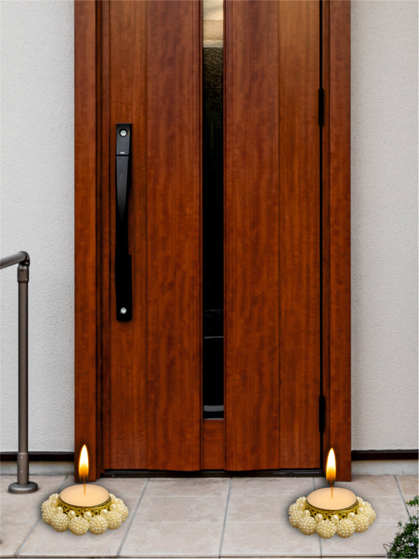 Wooden door with candles and floral arrangements on a pavement