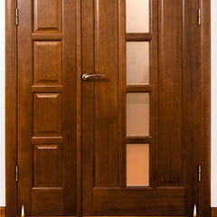 Wooden door with glass panels and candles on a wooden floor