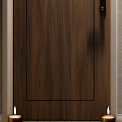 Wooden door with two lit candles on either side on a wooden floor.