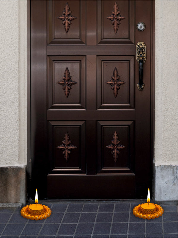 Dark wooden door with decorative panels and candles on a blue tiled floor.