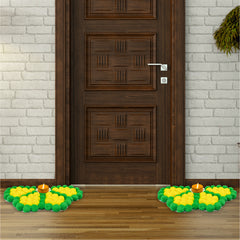 Decorative entrance mat with green and yellow flowers and candles in front of a wooden door.