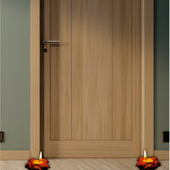 Wooden door with two lit candles on either side on a wooden floor.
