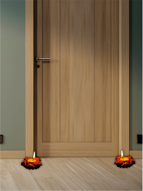 Wooden door with two lit candles on either side on a wooden floor.