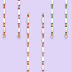 Set of beaded necklaces with red, green, and white beads on a purple background.