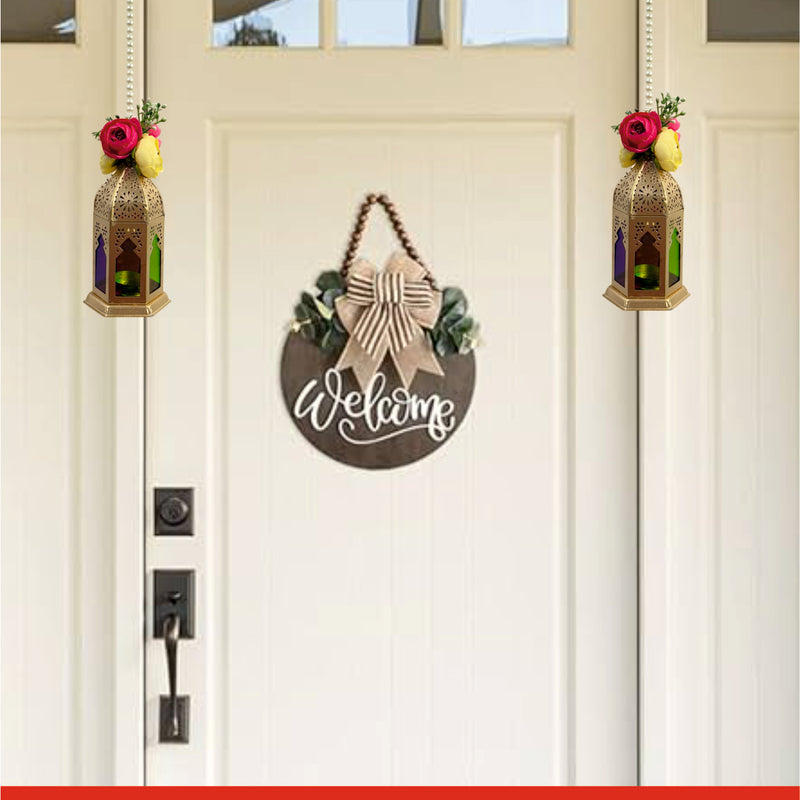 Decorative 'Welcome' sign hanging on a white door with two decorated jars.