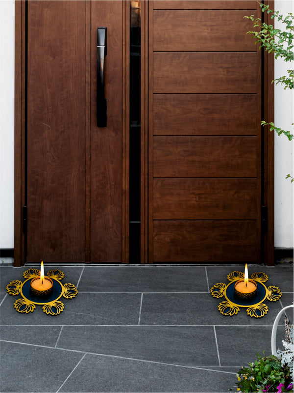 Wooden door with two lit candles on a stone floor, one with a decorative metal holder.