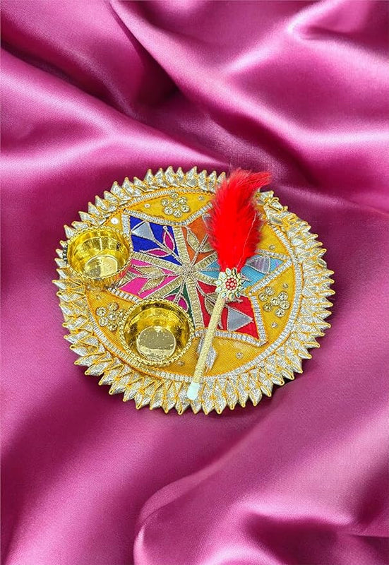 Decorative item with colorful design and red feather on a pink fabric background