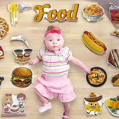 Baby surrounded by various food illustrations on a wooden surface