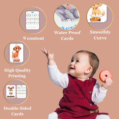 Baby holding a toy with educational cards displayed around on a brown background