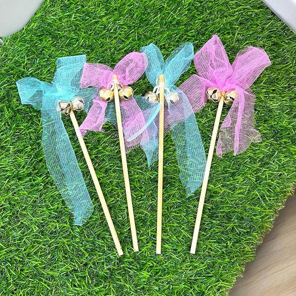 Decorative sticks with blue and pink ribbons on a grass-like surface