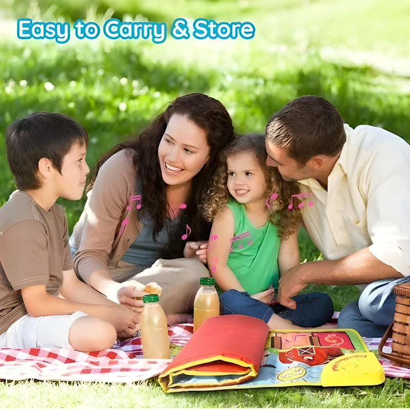 Family sitting on a picnic blanket with a colorful mat and drinks, enjoying a picnic outdoors.