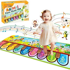Child playing on a colorful piano mat with animal illustrations and a toy box in the background.