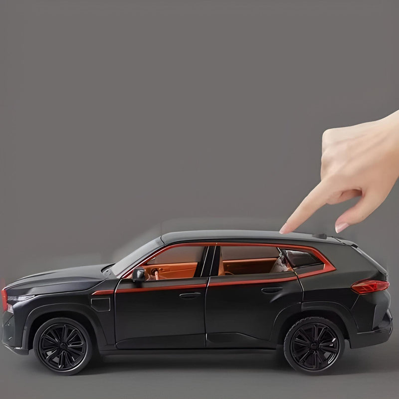 Black SUV model with a hand pointing at it on a gray background